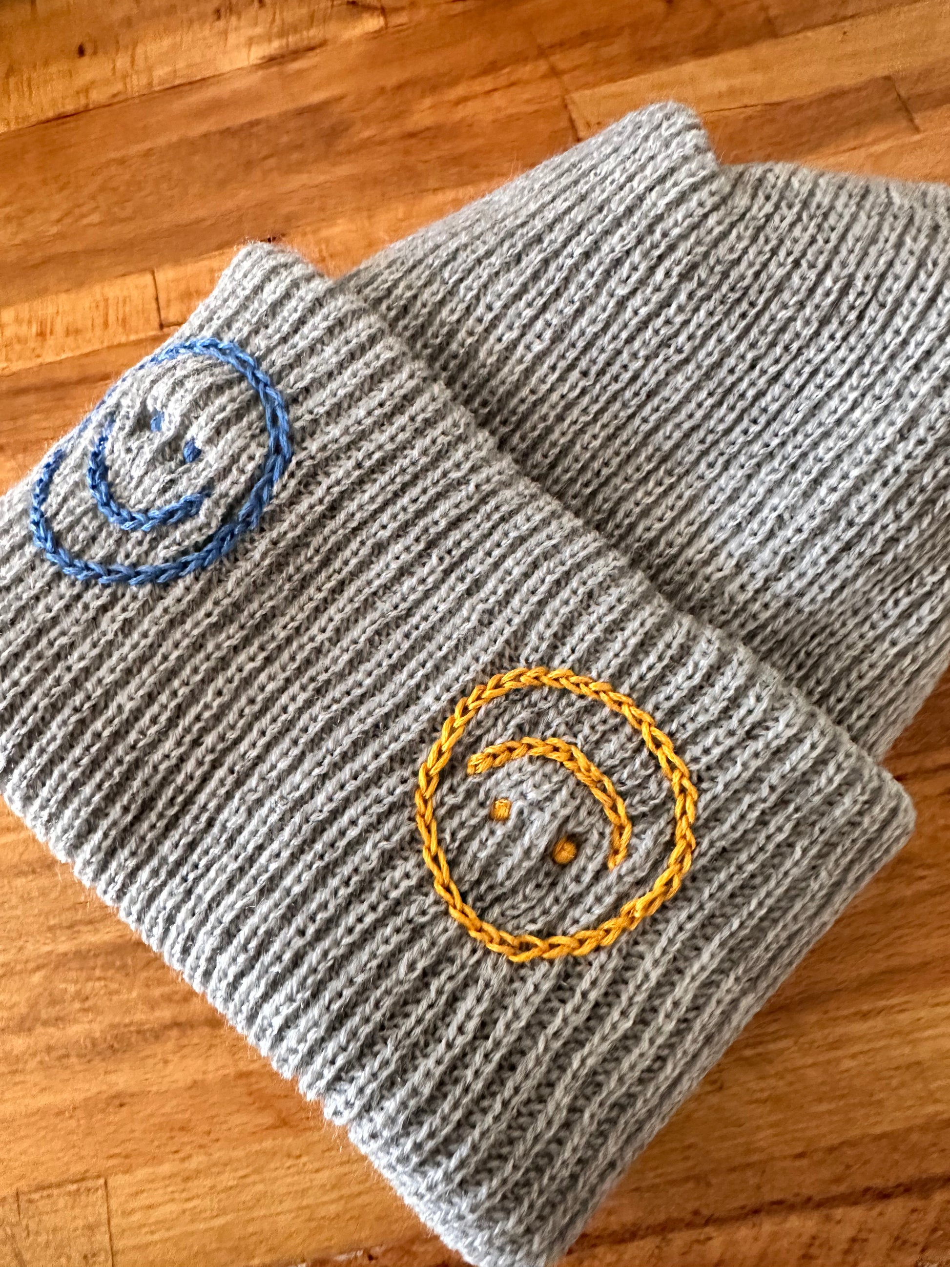 Light grey beanie with embroidered smiley faces 